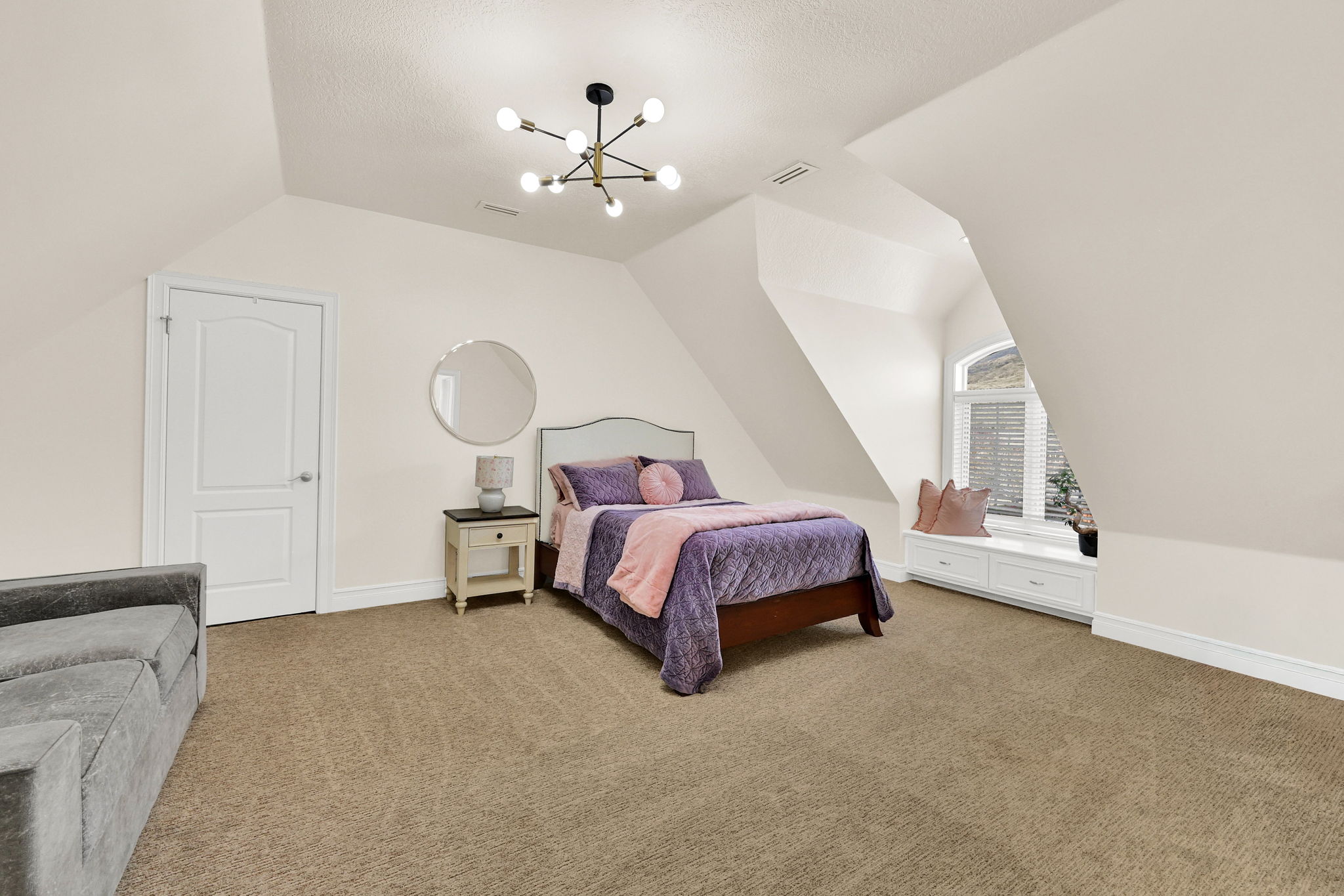 Guest bedroom with soft bedding and arched window seat