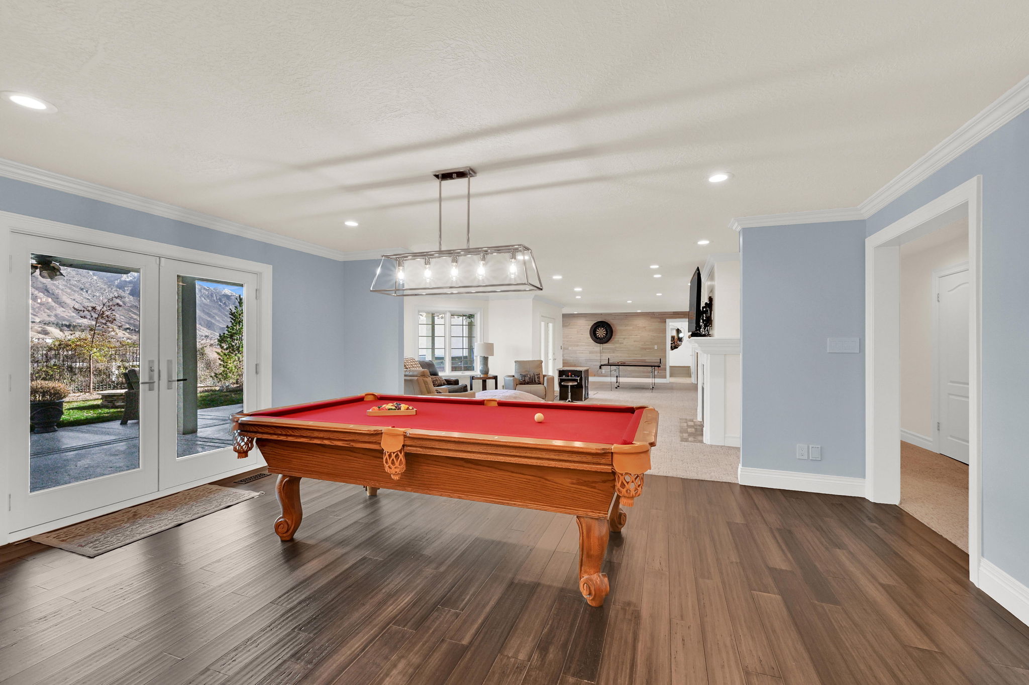 Lower living area with red pool table and doors opening to outdoor space